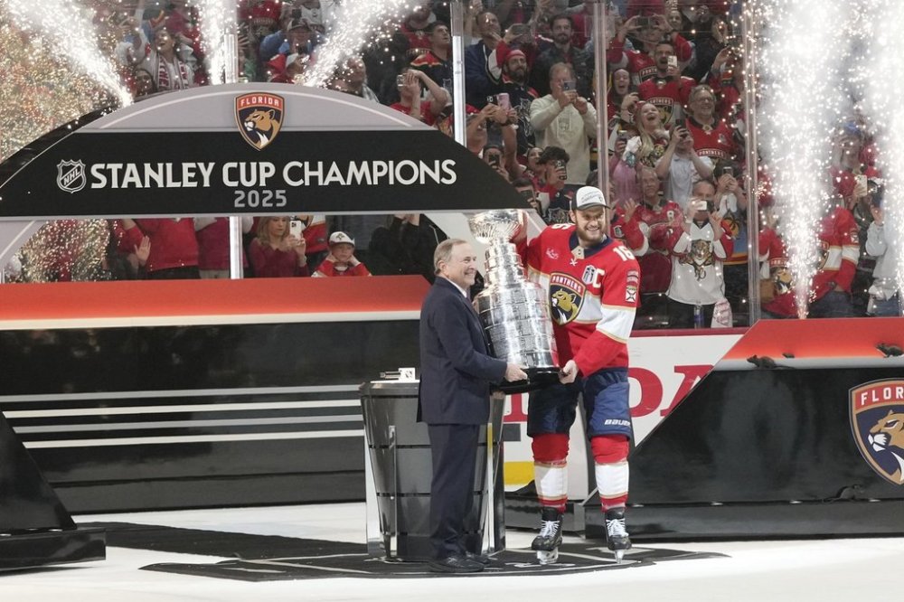 NHL commissioner Gary Bettman, left, hands the Stanley Cup to Florida Panthers captain Aleksander Barkov (16) after defeating the Edmonton Oilers in Game 6 of the NHL hockey Stanley Cup Final Tuesday, June 17, 2025, in Sunrise, Fla. (AP Photo/Lynne Sladky)