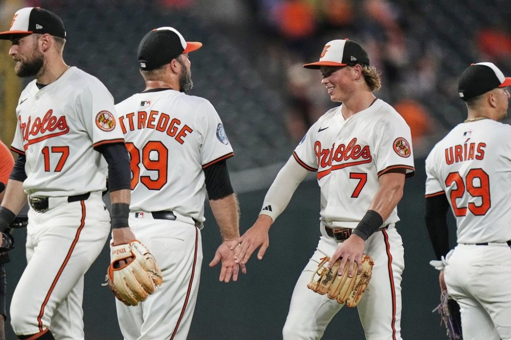 Baltimore Orioles' Jackson Holliday (7) and relief pitcher Andrew Kittredge, second from left, celebrate after their team's victory over the Texas Rangers in a baseball game, Monday, June 23, 2025, in Baltimore. (AP Photo/Stephanie Scarbrough)