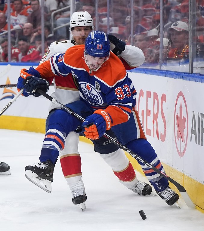 Oilers forward Ryan Nugent-Hopkins (93) and Florida Panthers defenceman Gustav Forsling (42) battle for the puck during the first overtime period in Game 2 of the NHL Stanley Cup final in Edmonton, on Friday, June 6, 2025. THE CANADIAN PRESS/Darryl Dyck