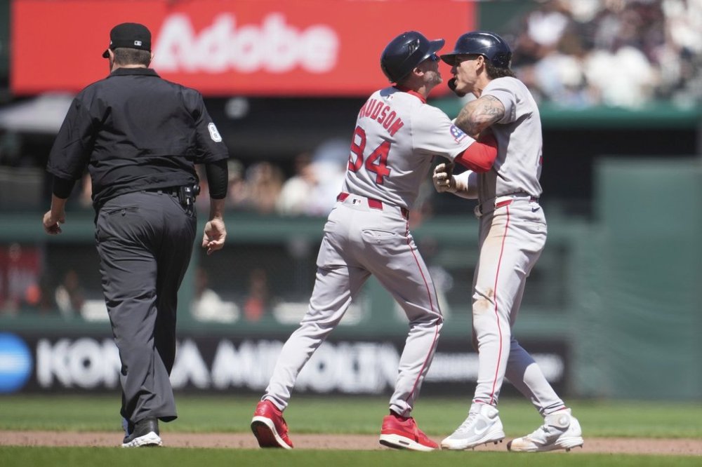 Boston Red Sox' Jarren Duran, right, is held back by third base coach Kyle Hudson (84) while arguing with umpire Doug Eddings, left, during the eighth inning of a baseball game against the San Francisco Giants in San Francisco, Sunday, June 22, 2025. (AP Photo/Jeff Chiu)