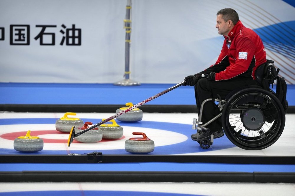 Mark Ideson of Canada helps his team line up a throw during their semifinal match against the United States at the World Wheelchair Curling Championship, a test event for the 2022 Winter Olympics, held at the Beijing National Aquatics Center, also known as the Water Cube, in Beijing, Friday, Oct. 29, 2021. Ideson was among 14 athletes named to Canada's national wheelchair curling program for 2025-26. (AP Photo/Mark Schiefelbein)