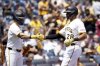 Pittsburgh Pirates' Tommy Pham, right, is greeted by Spencer Horwitz, left, after scoring during the seventh inning of a baseball game against the St. Louis Cardinals, Wednesday, July 2, 2025, in Pittsburgh. (AP Photo/Matt Freed)