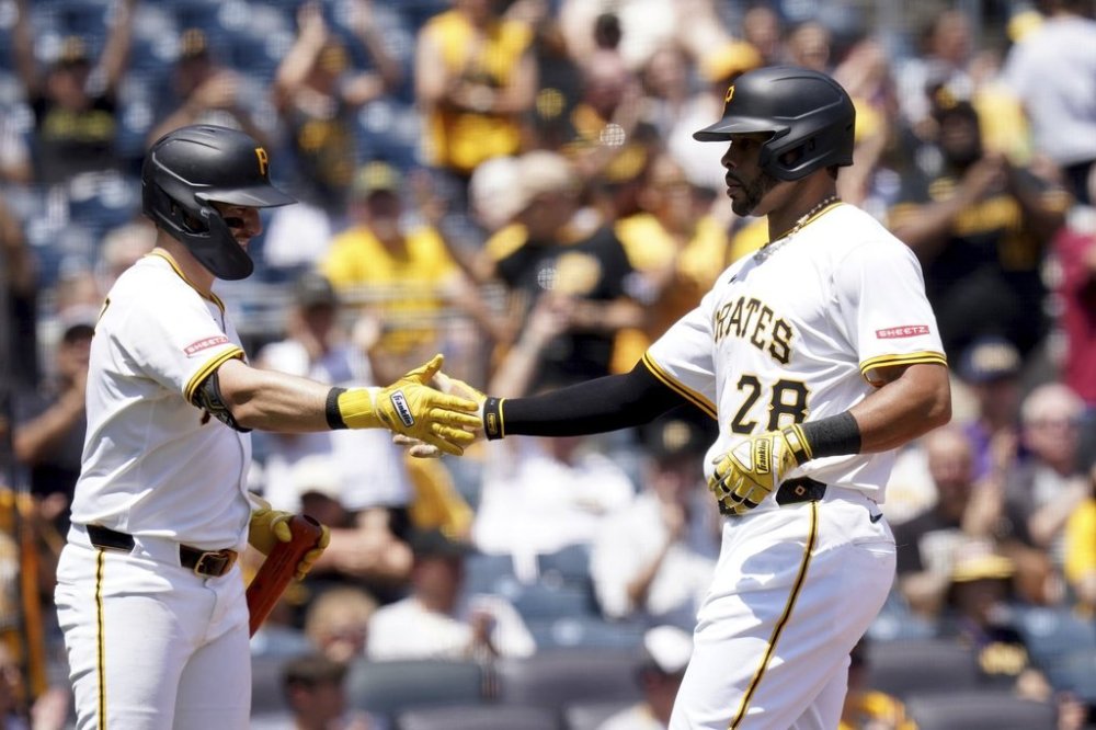 Pittsburgh Pirates' Tommy Pham, right, is greeted by Spencer Horwitz, left, after scoring during the seventh inning of a baseball game against the St. Louis Cardinals, Wednesday, July 2, 2025, in Pittsburgh. (AP Photo/Matt Freed)