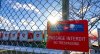 Canada Post trucks are seen behind a fence at a distribution centre in Montreal on Friday, Dec.13, 2024. THE CANADIAN PRESS/Christinne Muschi