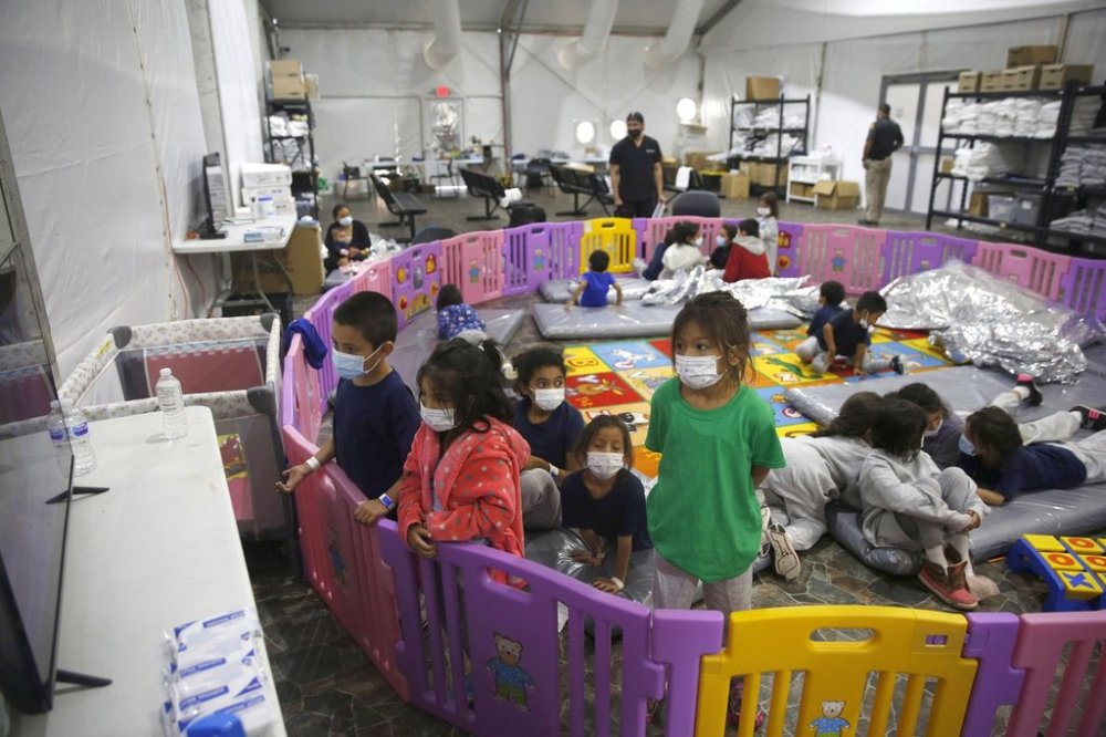 FILE - In this March 30, 2021, file photo, young unaccompanied migrants, watch television inside a playpen at the U.S. Customs and Border Protection facility, the main detention center for unaccompanied children in the Rio Grande Valley, in Donna, Texas. (AP Photo/Dario Lopez-Mills, Pool, File)