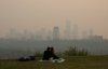 Smoke from wildfires blankets the city as a couple has a picnic in Edmonton, Saturday, May 11, 2024. THE CANADIAN PRESS/Jason Franson