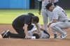 Detroit Tigers' Gleyber Torres, center bottom, is tended to after an injury at second base as manager A.J. Hinch, right, looks on during the first inning of a baseball game against the Cleveland Guardians, Saturday, July 5, 2025, in Cleveland. Torres was taken out of the game. (AP Photo/Phil Long)