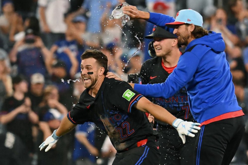 Toronto Blue Jays' Ernie Clement, left, celebrates with teammates after hitting a bunt single resulting in a throwing error from Los Angeles Angels relief pitcher Sam Bachman, permitting Blue Jays Myles Straw to score in tenth inning MLB baseball action in Toronto on Friday, July 4, 2025. THE CANADIAN PRESS/Jon Blacker