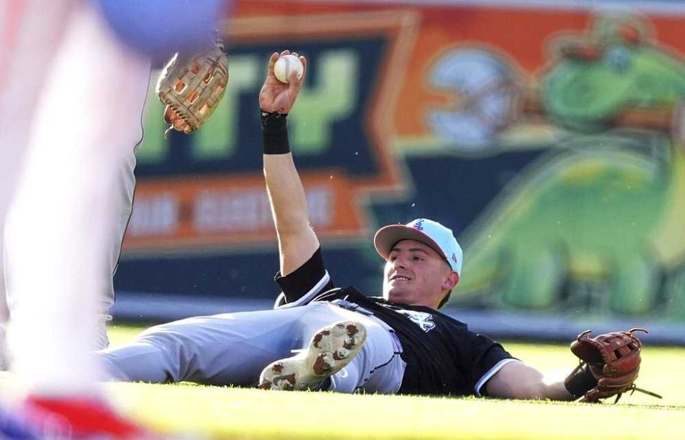 Chicago White Sox shortstop Colton Montgomery holds up the ball after fielding a short fly ball off the bat of Colorado Rockies' Ryan Ritter to end the second inning of a baseball game Friday, July 4, 2025, in Denver. (AP Photo/David Zalubowski)