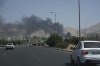 Cars drive on a highway as smoke rises from an oil storage facility after it appeared to have been struck by an Israeli strike on Saturday, in Tehran, Iran, Monday, June 16, 2025. (AP Photo/Vahid Salemi)