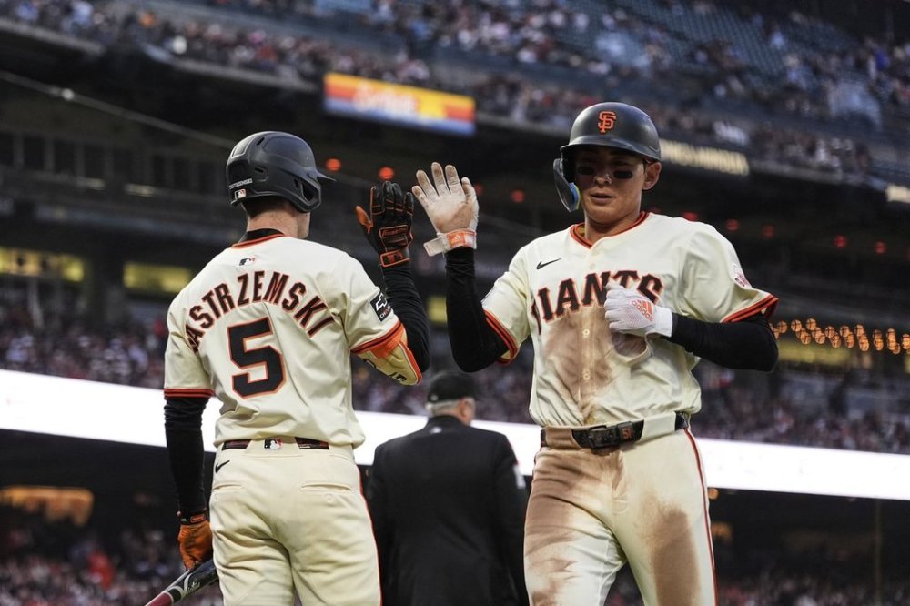 San Francisco Giants' Jung Hoo Lee, right, is congratulated by Mike Yastrzemski after scoring against the Miami Marlins on Christian Koss' sacrifice fly during the fifth inning of a baseball game Wednesday, June 25, 2025, in San Francisco. (AP Photo/Godofredo A. Vásquez)