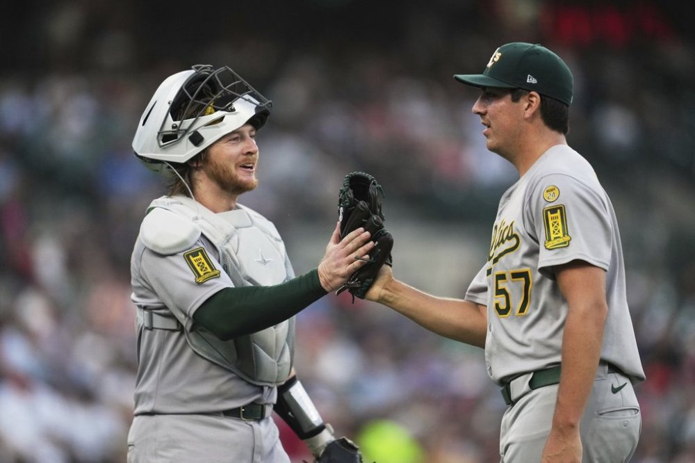 Athletics catcher Willie MacIver (65) and pitcher Jacob Lopez (57) react after the final out against the Detroit Tigers in the sixth inning during a baseball game, Wednesday, June 25, 2025, in Detroit. (AP Photo/Paul Sancya)