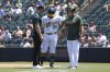 Athletics' Shea Langeliers (23) is looked at by a trainer and manager Mark Kotsay, right, before he was taken out of the game after taking a swing and grabbing his side during the sixth inning of a baseball game against the Minnesota Twins, Thursday, June 5, 2025, in West Sacramento, Calif. (AP Photo/Scott Marshall)