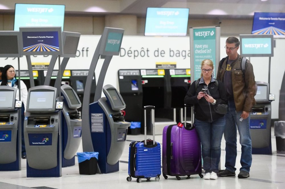 Passengers are seen in the WestJet check-in area at Pearson International Airport, in Toronto, Saturday, June 29, 2024. THE CANADIAN PRESS/Christopher Katsarov