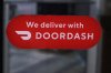 FILE - A DoorDash sign is posted on the door of a Dunkin' Donuts franchise, Feb. 27, 2023, in Methuen, Mass. DoorDash reports earnings on Thursday, Aug. 1, 2024. (AP Photo/Charles Krupa, File)