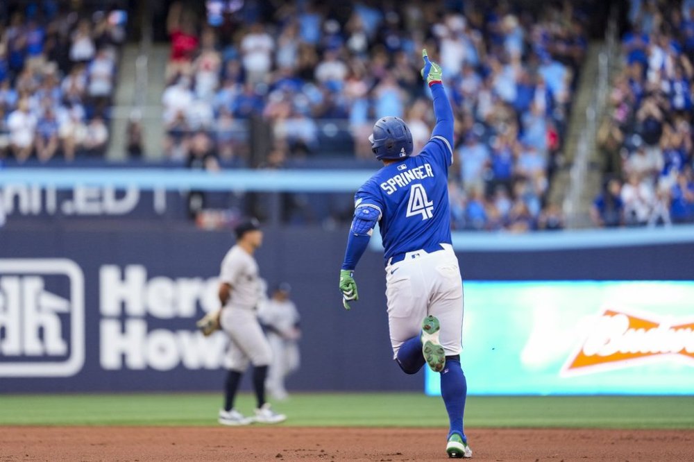 Toronto Blue Jays' George Springer (4) celebrates his two-run home run against the New York Yankees during third inning MLB baseball action, in Toronto on Thursday, July 3, 2025. THE CANADIAN PRESS/Thomas Skrlj