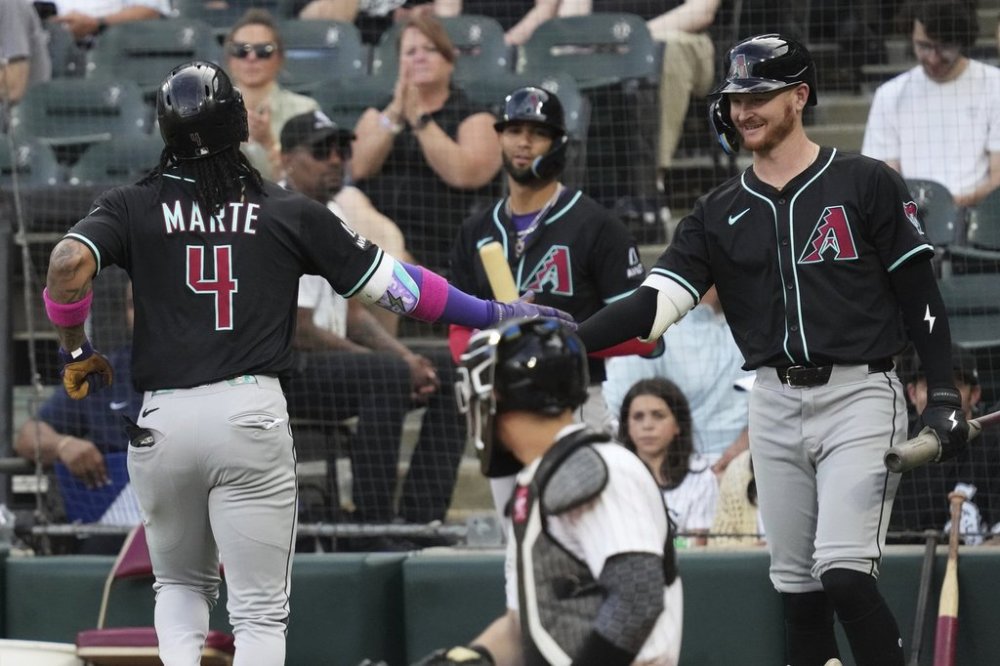 Arizona Diamondbacks' Ketel Marte (4) celebrates with Pavin Smith after hitting a solo home run during the first inning of a baseball game against the Chicago White Sox in Chicago, Tuesday, June 24, 2025. (AP Photo/Nam Y. Huh)
