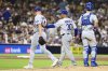 Los Angeles Dodgers' Matt Sauer, left, is relieved from a baseball game by manager Dave Roberts (30) as Dalton Rushing looks on in the sixth inning against the San Diego Padres Tuesday, June 10, 2025, in San Diego. (AP Photo/Derrick Tuskan)