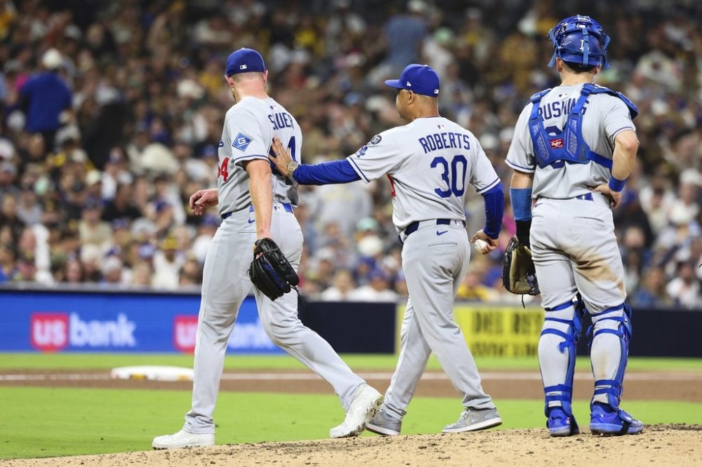 Los Angeles Dodgers' Matt Sauer, left, is relieved from a baseball game by manager Dave Roberts (30) as Dalton Rushing looks on in the sixth inning against the San Diego Padres Tuesday, June 10, 2025, in San Diego. (AP Photo/Derrick Tuskan)
