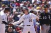 Colorado Rockies third base coach Andy González, left, congratulates Mickey Moniak after his triple to drive in two runs as Chicago White Sox third baseman Miguel Vargas, right, looks on in the fifth inning of a baseball game Sunday, July 6, 2025, in Denver. (AP Photo/David Zalubowski)