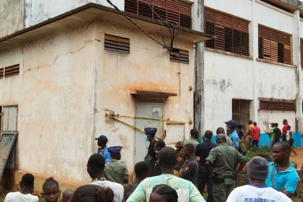 People gather at the site of an explosion and the stampede that followed that killed dozens of schoolchildren and injured hundreds at a high school in Central African Republic's capital city Bangui, authorities said Thursday, June 26, 2025. (AP Photo/Jean Fernand Koena)