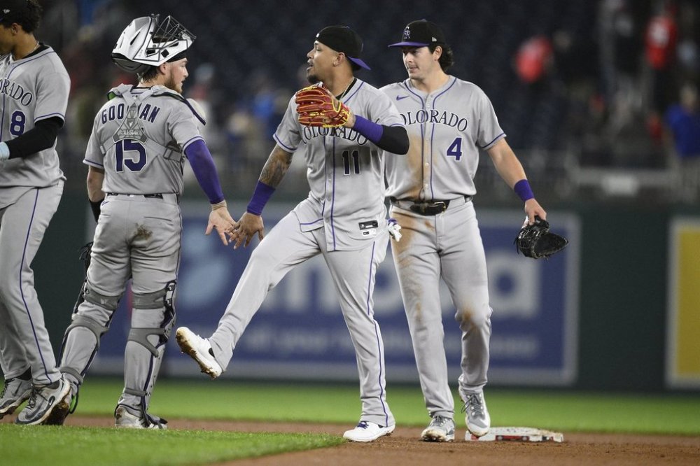 Colorado Rockies catcher Hunter Goodman (15), Orlando Arcia (11) and Michael Toglia (4) celebrate after a baseball game against the Washington Nationals, Monday, June 16, 2025, in Washington. (AP Photo/Nick Wass)