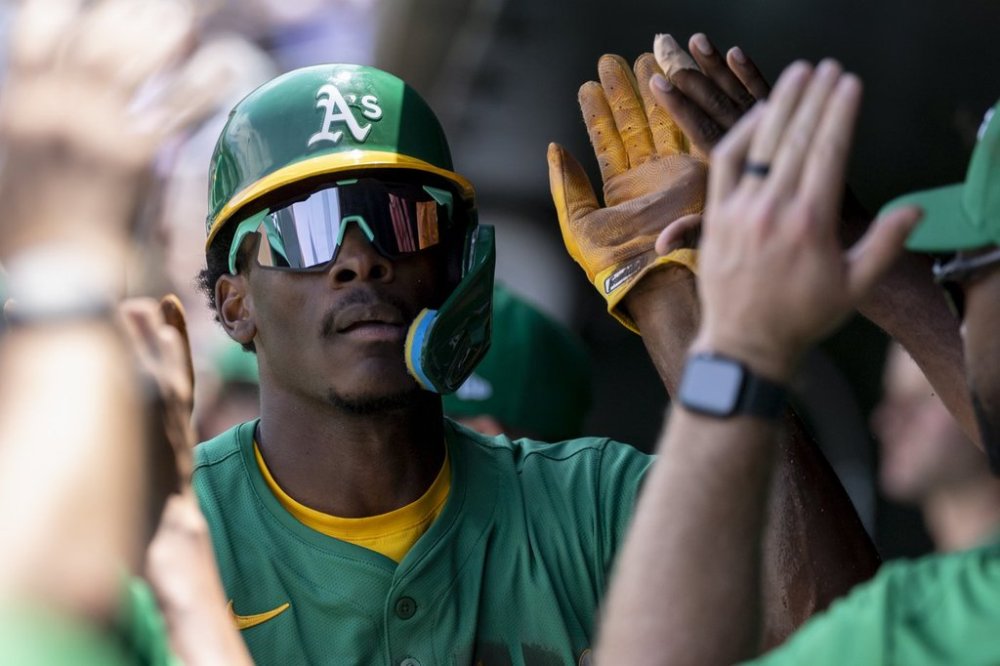 Athletics' Denzel Clarke celebrates in the dugout after scoring during the second inning of a baseball game against the Baltimore Orioles Sunday, June 8, 2025, in West Sacramento, Calif. (AP Photo/Sara Nevis)
