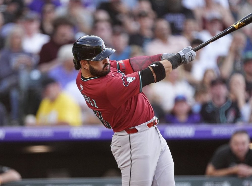 Arizona Diamondbacks' Eugenio Suárez singles off Colorado Rockies starting pitcher Austin Gomber in the third inning of a baseball game Friday, June 20, 2025, in Denver. (AP Photo/David Zalubowski)