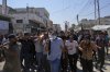 Palestinians, some armed, carry the body of Farouq Khattab, 29, who was killed in an Israeli army airstrike of the Gaza Strip, during his funeral in Deir al-Balah, Wednesday, July 2, 2025. (AP Photo/Abdel Kareem Hana)