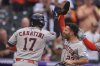 Houston Astros' Jose Altuve, right, congratulates Victor Caratini after his grand slam off Colorado Rockies starting pitcher Chase Dollander in the third inning of a baseball game Tuesday, July 1, 2025, in Denver. (AP Photo/David Zalubowski)