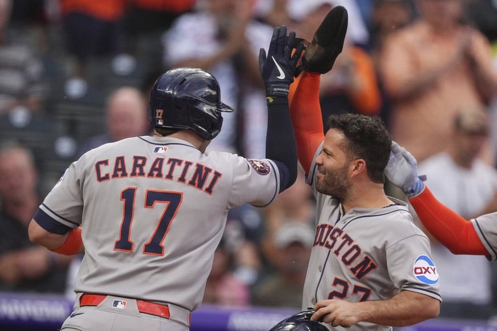 Houston Astros' Jose Altuve, right, congratulates Victor Caratini after his grand slam off Colorado Rockies starting pitcher Chase Dollander in the third inning of a baseball game Tuesday, July 1, 2025, in Denver. (AP Photo/David Zalubowski)