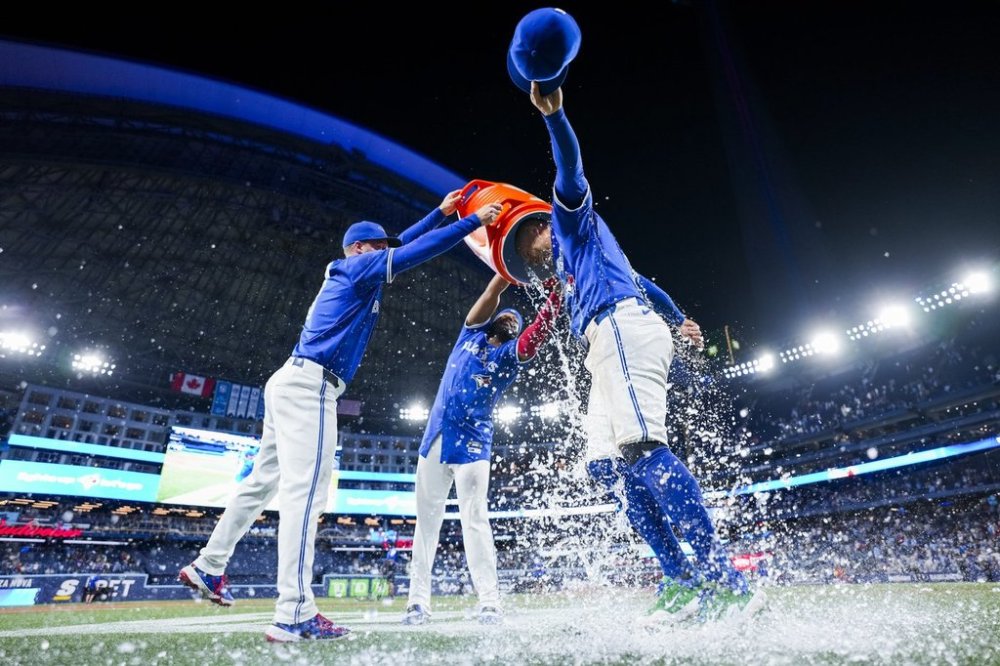 Toronto Blue Jays' George Springer (right) is doused by teammates after defeating the New York Yankees, in Toronto on Thursday, July 3, 2025. THE CANADIAN PRESS/Thomas Skrlj