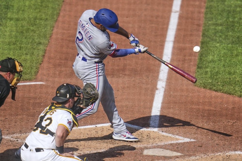 Texas Rangers' Marcus Semien (2) drives in a run with a sacrifice fly off Pittsburgh Pirates pitcher Mitch Keller during the sixth inning of a baseball game in Pittsburgh, Saturday, June 21, 2025. (AP Photo/Gene J. Puskar)