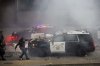 A California Highway Patrol officer pulls an electric scooter off a vehicle on a highway as protesters throw objects at the police vehicles near the Metropolitan Detention Center in downtown Los Angeles, Sunday, June 8, 2025. (AP Photo/Ethan Swope)