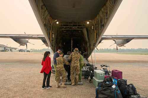 Members of the Royal Canadian Air Force help evacuees board a C-130 Hercules aircraft in Norway House, Man., Tuesday, June 3, 2025, at the Norway House Airport as crews continue to fight wildfires in northern Manitoba. THE CANADIAN PRESS/David Lipnowski