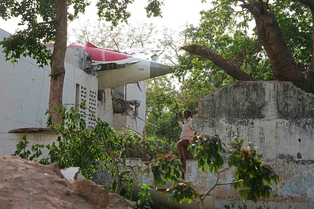 The debris of an airplane sticks out of a building after it crashed in India's northwestern city of Ahmedabad in Gujarat state, Thursday, June 12, 2025. (AP Photo/Ajit Solanki)