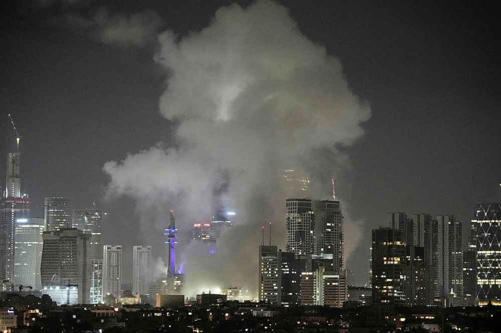 Smoke rises after a missile attack in Tel Aviv, Israel, Friday, June 13, 2025. (AP Photo/Leo Correa)