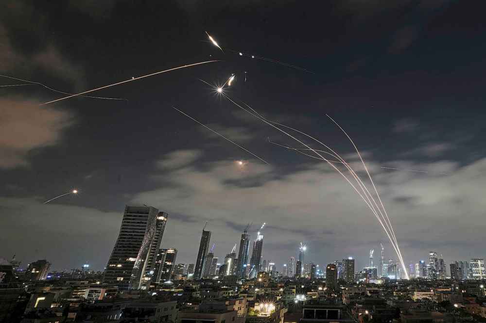 The Israeli Iron Dome air defense system fires to intercept missiles during an Iranian attack over Tel Aviv, Israel, Sunday, June 15, 2025. (AP Photo/Leo Correa)