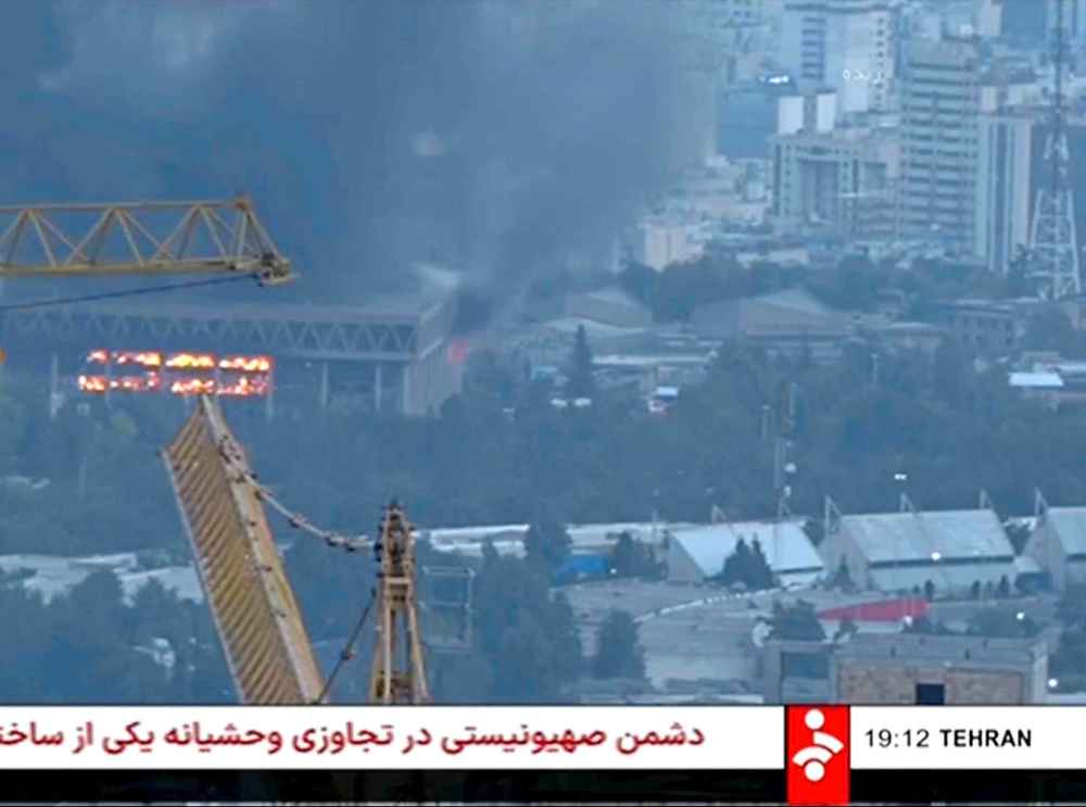 This frame grab from a video released by Iran state TV shows the the network building on fire after an Israeli drone attack, June 16, 2025, in Tehran, Iran. (Iran state TV, IRINN via AP)
