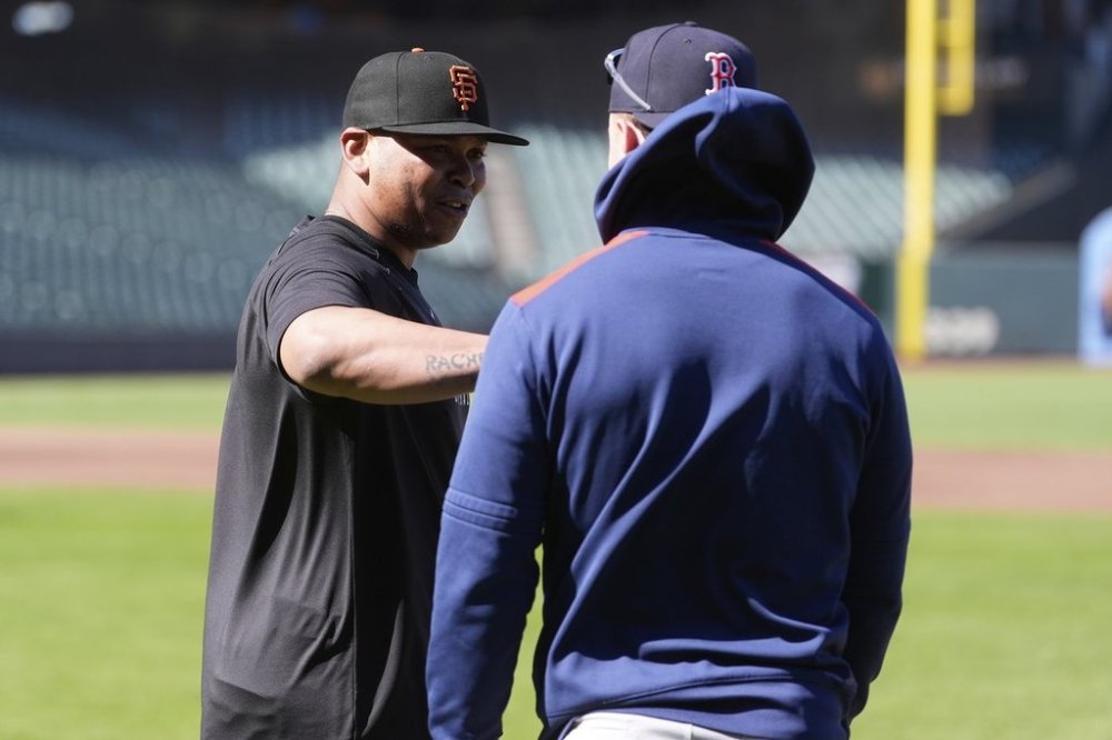 San Francisco Giants' Rafael Devers, left, talks with Boston Red Sox's Romy Gonzalez before a baseball game in San Francisco, Friday, June 20, 2025. (AP Photo/Jeff Chiu)
