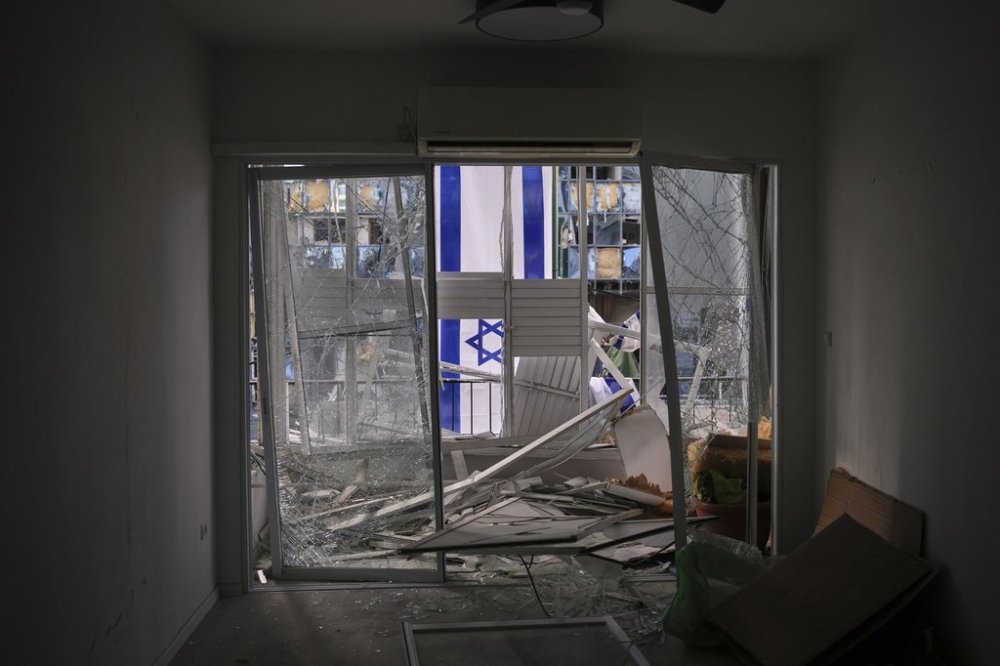 An Israeli flag is hung outside a damaged apartment two days after it was struck by a missile launched from Iran, in Ramat Gan, Israel, on Saturday, June 21, 2025. (AP Photo/Ohad Zwigenberg)