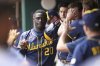 Milwaukee Brewers' Daz Cameron is congratulated in the dugout after scoring in the eighth inning of a baseball game against the Cincinnati Reds, Wednesday, June 4, 2025, in Cincinnati. (AP Photo/Kareem Elgazzar)