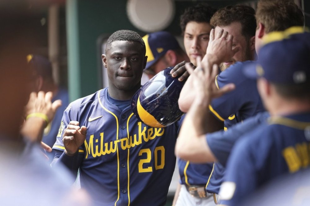 Milwaukee Brewers' Daz Cameron is congratulated in the dugout after scoring in the eighth inning of a baseball game against the Cincinnati Reds, Wednesday, June 4, 2025, in Cincinnati. (AP Photo/Kareem Elgazzar)