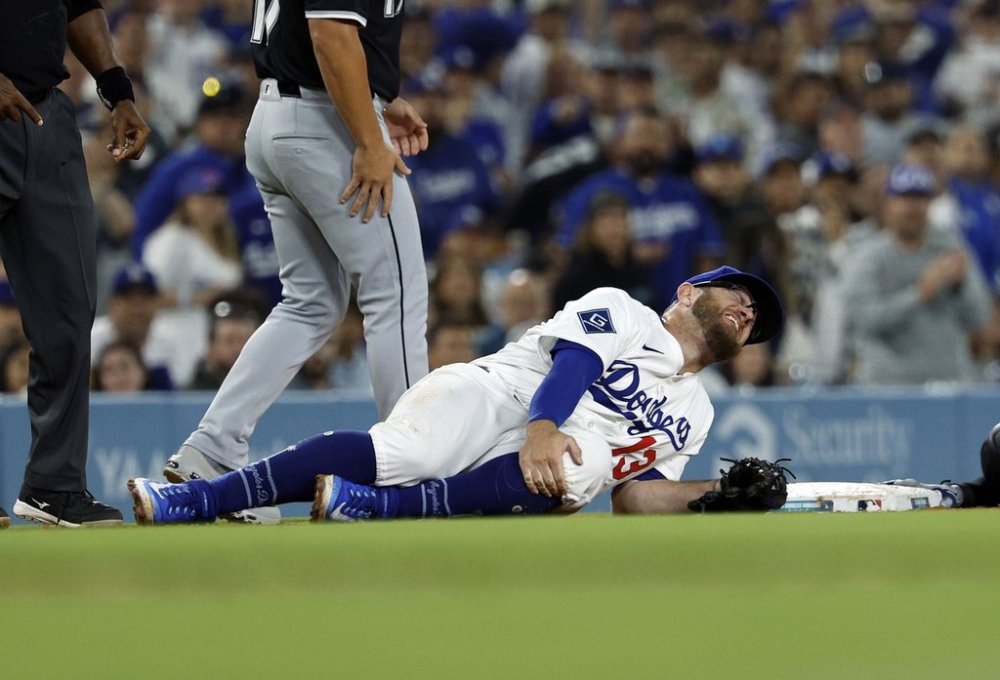 Los Angeles Dodgers' Max Muncy holds his knee after tagging out Chicago White Sox's Michael A. Taylor attempting to steal third base during the during the sixth inning Wednesday, July 2, 2025, in Los Angeles. (AP Photo/Kevork Djansezian)