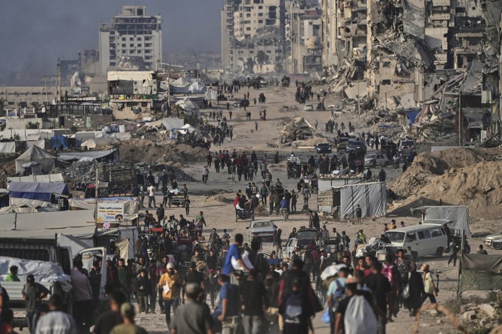 Displaced Palestinians walk past the ruins of destroyed buildings along the Gaza City shoreline on Monday, June 9, 2025. (AP Photo/Jehad Alshrafi)