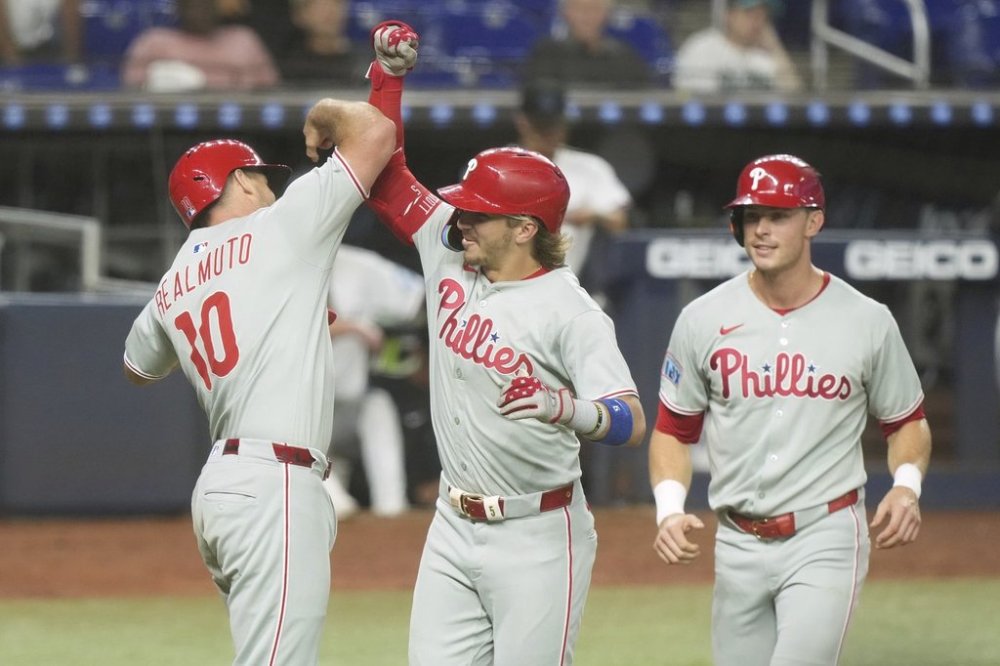 Philadelphia Phillies' Bryson Stott, center, celebrates with J.T. Realmuto (10) and Max Kepler after hitting a three-run home run during the fourth inning of a baseball game against the Miami Marlins, Wednesday, June 18, 2025, in Miami. (AP Photo/Marta Lavandier)
