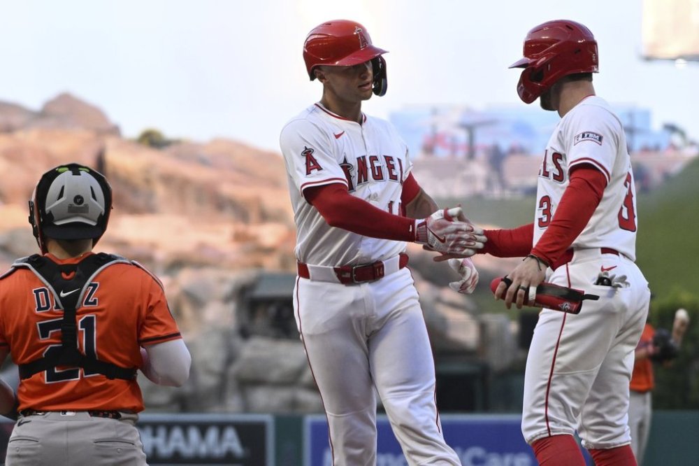 Los Angeles Angels Logan O'Hoppe, center, celebrates after his two-run home run with teammate Taylor Ward (3) near Houston Astros catcher Yainer Diaz (21) in the third inning of a baseball game Saturday, June 21, 2025, in Anaheim, Calif. (AP Photo/Wally Skalij)