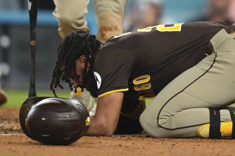 San Diego Padres' Fernando Tatis Jr. kneels on the ground after being hit by a pitch during the ninth inning of a baseball game against the Los Angeles Dodgers, Thursday, June 19, 2025, in Los Angeles. (AP Photo/Mark J. Terrill)
