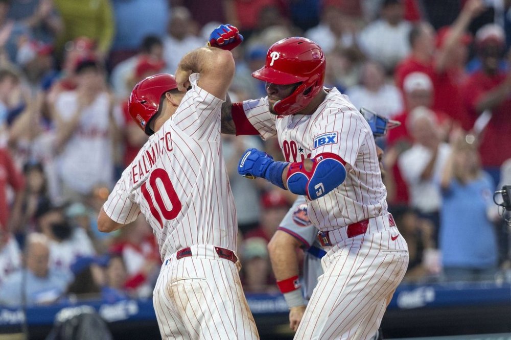 Philadelphia Phillies' Edmundo Sosa, right, celebrates his three-run home run with J.T. Realmuto (10) during the fourth inning of a baseball game against the New York Mets, Sunday, June 22, 2025, in Philadelphia. (AP Photo/Laurence Kesterson)