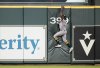 Athletics center fielder Denzel Clarke (1) tries to reach for Houston Astros' Jose Altuve's two-run home run during the fourth inning of a baseball game, Tuesday, May 27, 2025, in Houston. (AP Photo/Karen Warren)